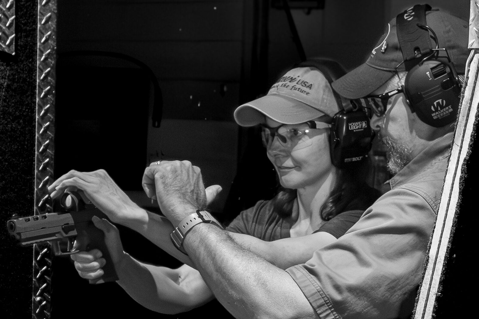 Owner Darren S. Brickle teaches a shooting range customer about racking techniques for her firearm.